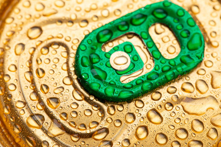 Cold metal beer can with water drops. Alcoholic drink. Canned drinks. Gold-colored lids.の写真素材