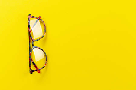 Eye glasses vision. Round glasses with transparent lenses on a yellow background. Fashion accessory. Eyesight correction.の写真素材