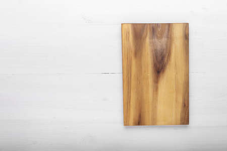 Cutting wooden board of rectangular shape on a wooden background. Space for text. Top view.