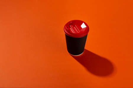 Black coffee paper cup on an orange background.の写真素材