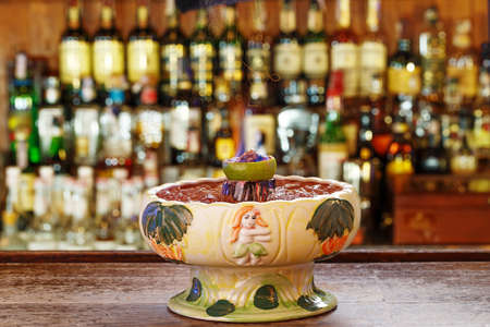 Strong alcoholic cocktail zombie volcano. Drink on blurred background of the bar. Space for textの写真素材