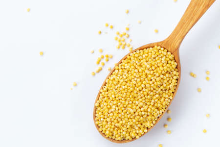 Dry millet in a wooden spoonの写真素材