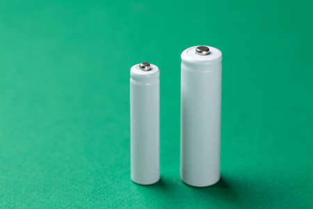 Several AA batteries in close up on a green background. Alkaline battery. File contains clipping...