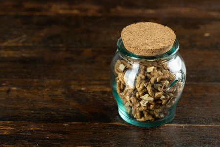 Walnut in in a glass jar on wooden background with copy space. Space for text.の写真素材