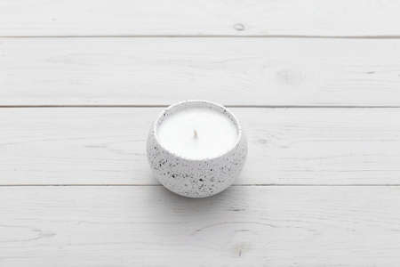 Wax candle on a white wooden background. Decor, home comfort, romantic mood. Space for text.の写真素材