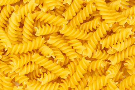 Close-up of raw pasta, texture or background Fusilli. Raw and Dry Macaroni. Italian Culture. Top view.の写真素材