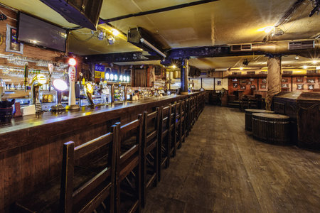 Kiev, Ukraine- March 19, 2018. empty wooden seating and tables in a beer pub. traditional beer pub with wooden interiorのeditorial素材