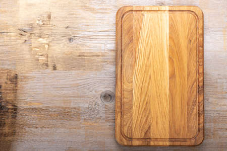 Cutting board on a wooden old background. Space for text. top view.