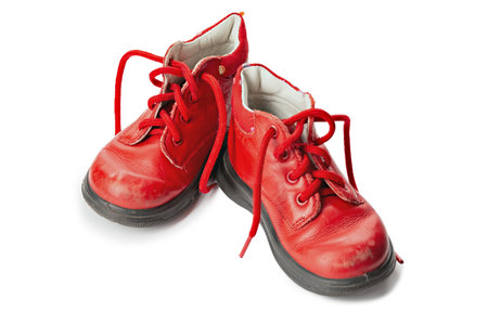 Worn out kiddie-size red lace-ups. Children's shoes with laces. Old ankle boots for small kid.の写真素材