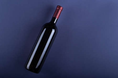 Bottle of red wine without a label on a purple paper background. Mockup drink with place for you label and text. Space for text.Top view.の写真素材