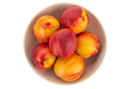 Fresh nectarines fruits in bowl isolated on white background.の写真素材