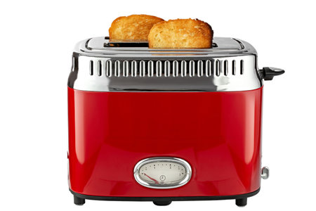 Modern red toaster with toasted bread for breakfast inside, isolated on white background. File contains clipping path. Full depth of field.の写真素材