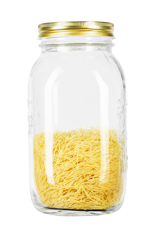 Glass jar filled Filini raw pasta isolated on white background. File contains clipping path. Traditional Italian pasta. Top view.の写真素材