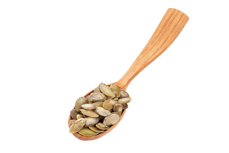 Pumpkin seeds in wood spoon isolated on a white background. Healthy food ingredient. File contains clipping path.の写真素材