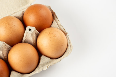 Raw chicken eggs in an egg tray on a white background. Space for text.の写真素材