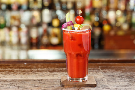 A cocktail with vodka and tomato juice, in a glass garnished with cherry tomatoes, celery, onions, lemon and lime. Space for text designの写真素材