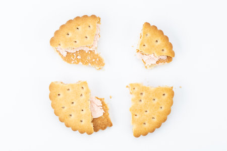 Stacked sandwich biscuits with pink cream filling. Sandwich cookies broken on a white background.の写真素材