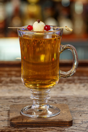 Non-alcoholic mulled wine, garnished with apple, with spices in a glass stands against the backdrop of a bar in a restaurant or in a pub. Space for text designの写真素材