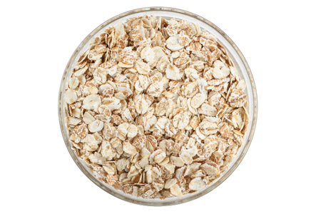 raw oatmeal in a plate, isolated on a white backgroundの写真素材