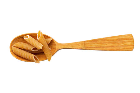 Whole Grain penne pasta from durum wheat in wood spoon isolated on white background. Healthy eating concept. Penne Rigate. File contains clipping path. Top view.の写真素材