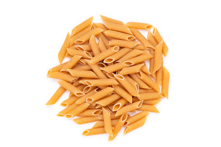 Whole Grain penne pasta from durum wheat on white background. Healthy eating concept. Penne Rigate. Top view.の写真素材