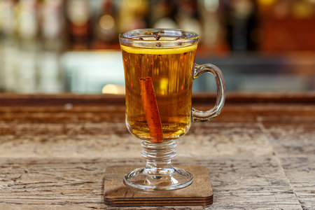 Non-alcoholic mulled wine in a glass, a hot drink stands on a wooden bar counter in a restaurantの写真素材