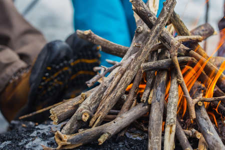 A bonfire is burning In winter in outdoors. Heating feet from fireの写真素材