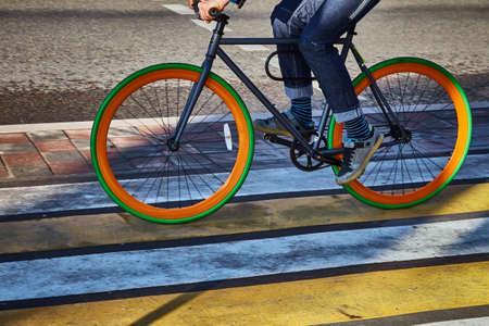 A cyclist in the city goes on a pedestrian crossing. Eco-friendly mode of transportの写真素材