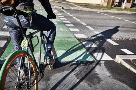 A cyclist is riding a bike path. Bicycle in the city. Eco-friendly mode of transport. Morning in the cityの写真素材