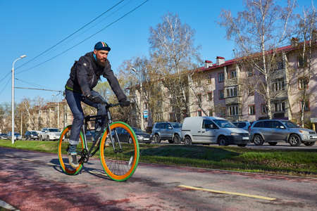 A cyclist in the city is moving along a bicycle path. Eco-friendly mode of transport. Bicycle with fixed speedの写真素材
