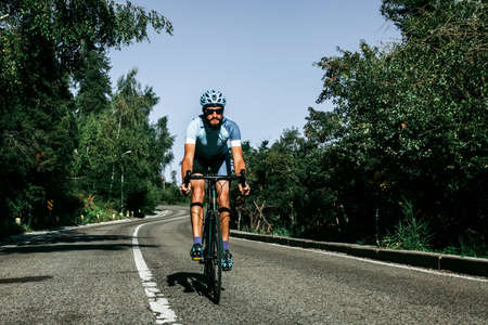 A man riding a bicycle on a mountain road. Kazakhstan, Almaty, Medeoの写真素材