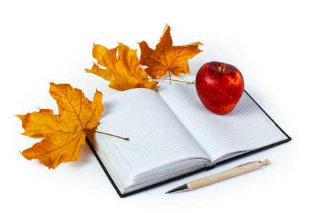 Writing-book, ballpen, apple and yellow maple leaves. On a white background. Isolatedの写真素材