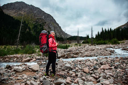 Trekking in the mountains. The girl on the shore of a mountain river. Kazakhstan. Valley Left Talgar Riverの写真素材
