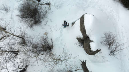 Hiker in the mountains walks on snowshoes. View from above. A man rises to the top. Winter mountain tourism. Kazakhstanの写真素材