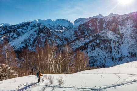 A young man travels in the snowy mountains in the winter on skis. Ski tour.の写真素材