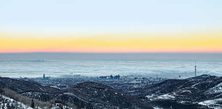Early winter morning, fog and smog over the city of Almaty, Kazakhstan. Panoramic photoの写真素材