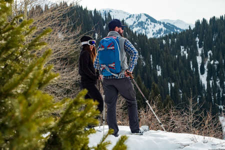 The guy with the girl in the winter in the mountains. Winter outdoor tourism on snowshoes. Mountains Tien Shan. Kazakhstanの写真素材