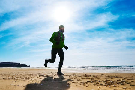 A man athlete runs along the seashore on a sunny day. Trail Running. Mangystau Peninsula. Kazakhstanの写真素材