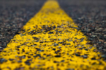 Road marking line with yellow paint on asphalt. Marking the motorway. Close-upの写真素材