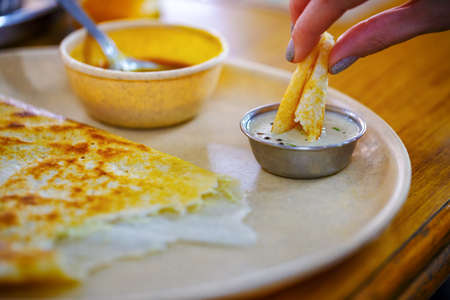 Dosa. Popular South Indian Food. Girl eats dosa, close-upの写真素材