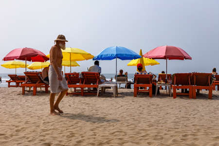 ARAMBOL, GOA, INDIA - JANUARY 17: An elderly bearded man is walking along the beach. Carefree life in a tropical country.のeditorial素材