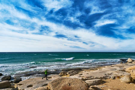 A man athlete runs along the seashore on a sunny day. Trail Running. Mangystau Peninsula. Kazakhstan