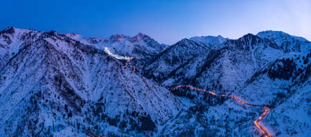 Panorama of the mountains with the road to the ski resort of Chimbulak. Late winter eveningの写真素材