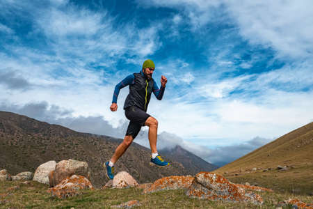 Bearded man athlete jogging outdoors in the mountains. Training high in the mountains. Sky running