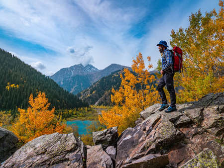 Man outdoors in the mountains. Autumn on the Issyk mountain lake
