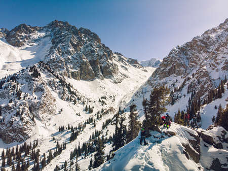 Almaty Region, Kazakhstan - FEBRUARY 28, 2021: Climbers on the top of a small rock. Winter training of climbers in the mountains. Mountaineering school in Almatyのeditorial素材