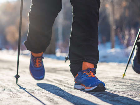 Close-up - legs of a man, Nordic walking in winter. Recreation fitness and healthy lifestyle outdoors in nature. Motivation and inspirational winter landscape.の写真素材