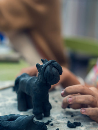 Black clay figurine molded by a child. Manual labor, early development, fine motor skills. Children's artの写真素材