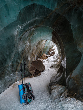 Inside the ice cave of a mountain glacier. A tourist's backpack in an ice cave. Bogdanovich Glacierの写真素材
