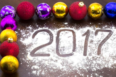 New Year's multi-colored Christmas balls on a wooden table.